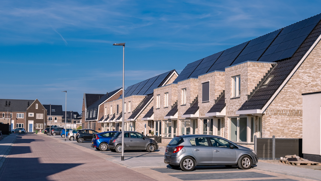 Newly build houses with solar panels attached on the roof against a sunny sky Close up of new building with black solar panels. Zonnepanelen, Zonne energie, Translation: Solar panel, , Sun Energy.